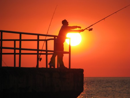 A smelly piece of bait, an orange sunset, and the perfect cast bring the promise of a fine fish dinner. 